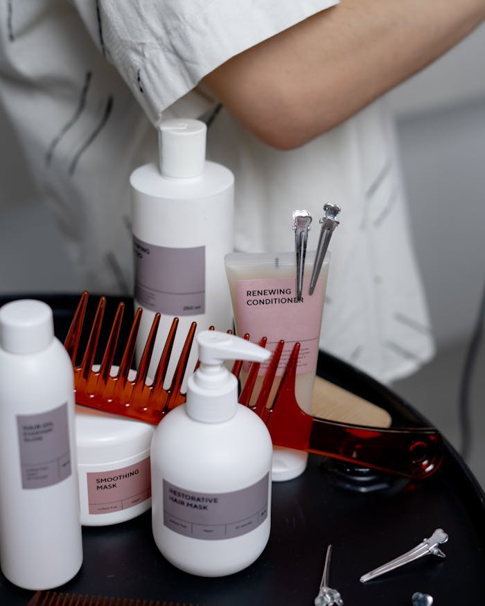 services-03 A collection of haircare products including shampoos, conditioners, and combs neatly arranged on a table.