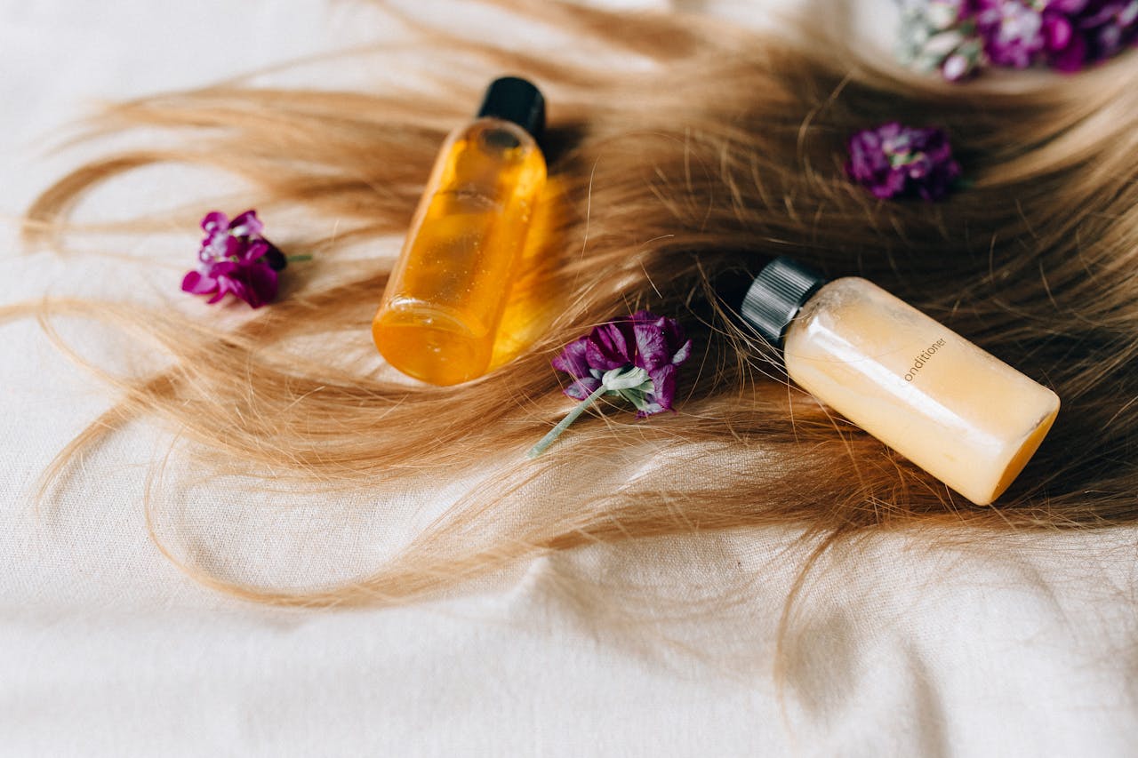 journey Hair care products on a bed of hair and flowers, symbolizing luxury and beauty.